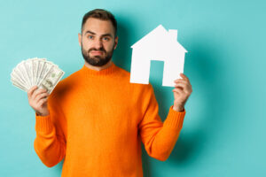 Sad man showing house market and money