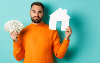 Sad man showing house market and money