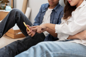 Young couple moving home and reviewing options on phone